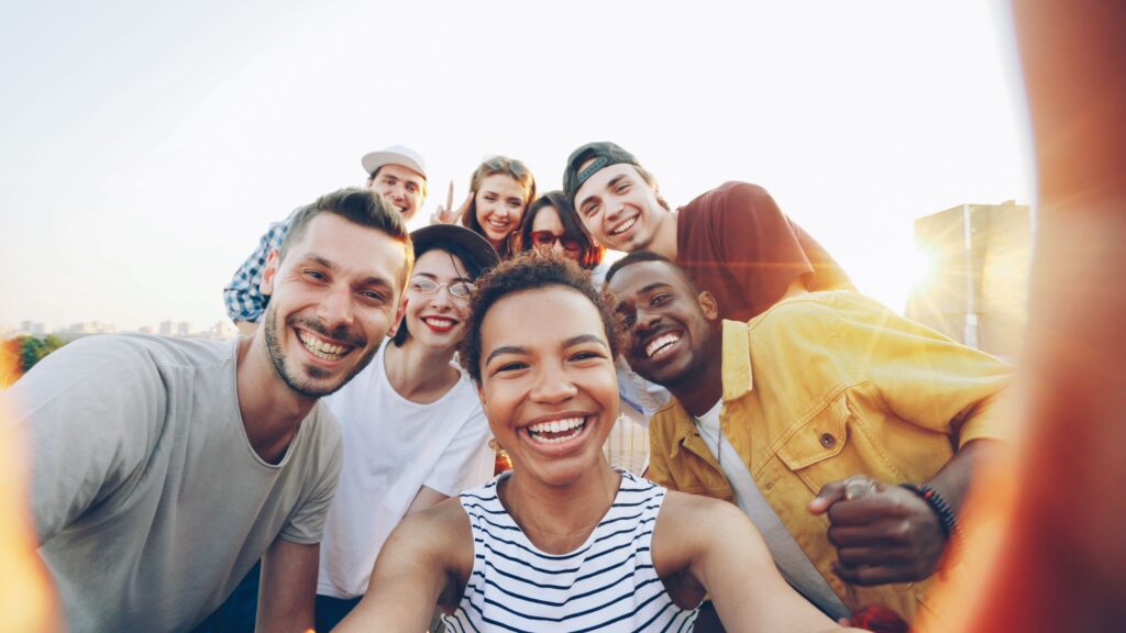 pexels photo 36729918 36729918 A diverse group of friends taking a joyful selfie outdoors during sunset.